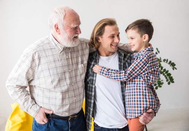 Foto grátis homens de família de diferentes gerações abraçando juntos