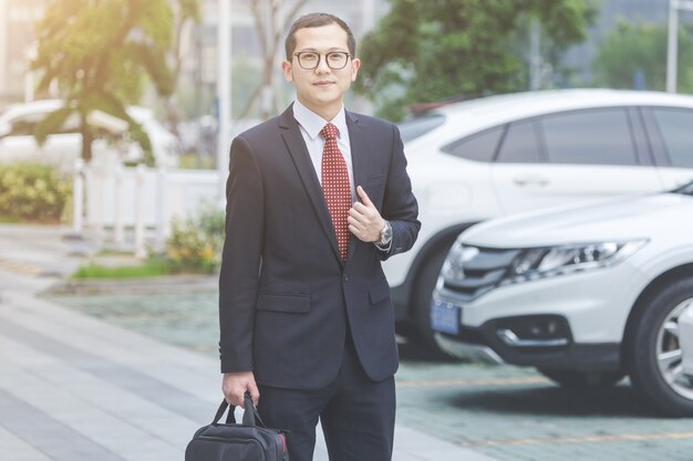 Homens de negócios carregam laptops no estacionamento