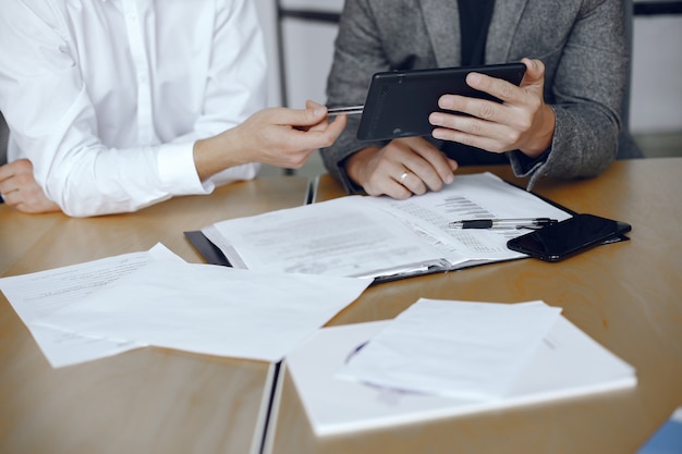 Homens de negócios sentados à mesa dos advogados. Pessoas assinando documentos importantes.