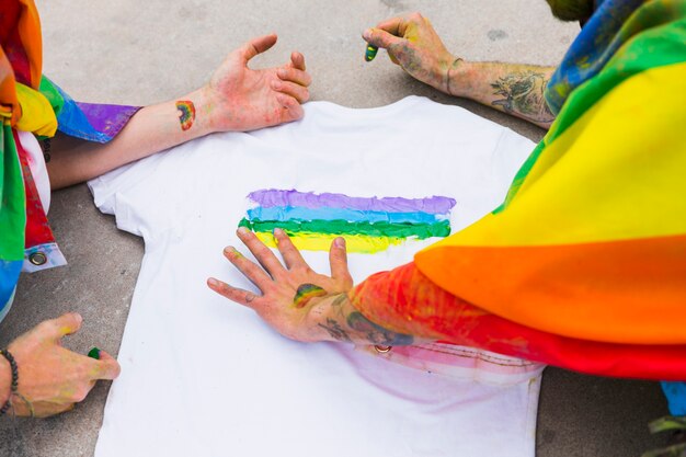 Homens desenhando arco-íris em t-shirt