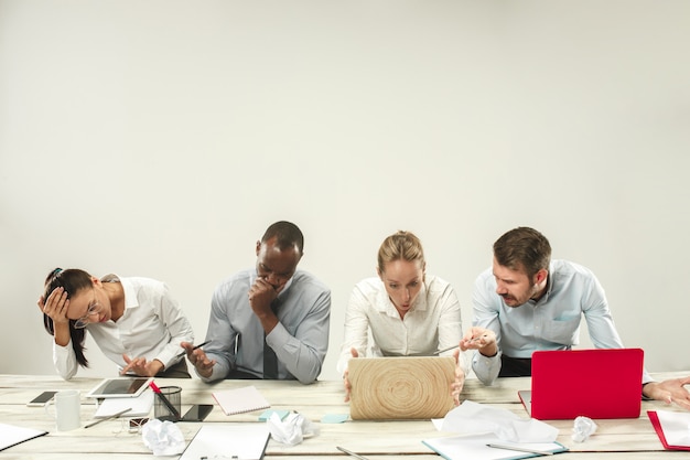 Homens e mulheres jovens sentados no escritório e trabalhando em laptops. conceito de emoções