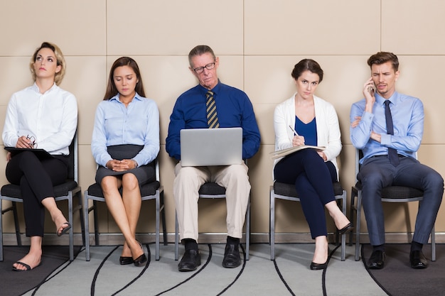 Homens e Mulheres sentado e esperando para Entrevista