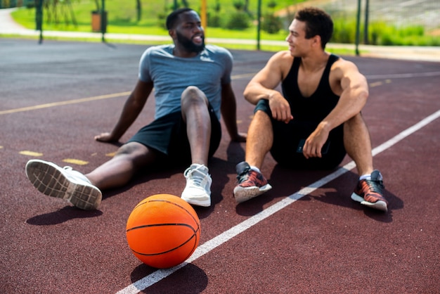 Homens falando na quadra de basquete