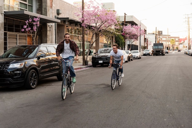 Foto grátis homens felizes andando de bicicleta na cidade