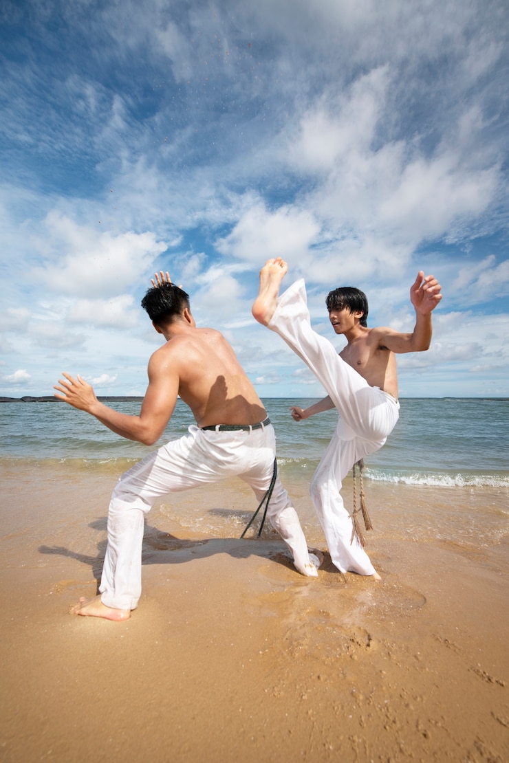 Foto grátis homens na praia praticando capoeira juntos