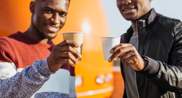 Homens negros em meio a tiro tomando café em um food truck