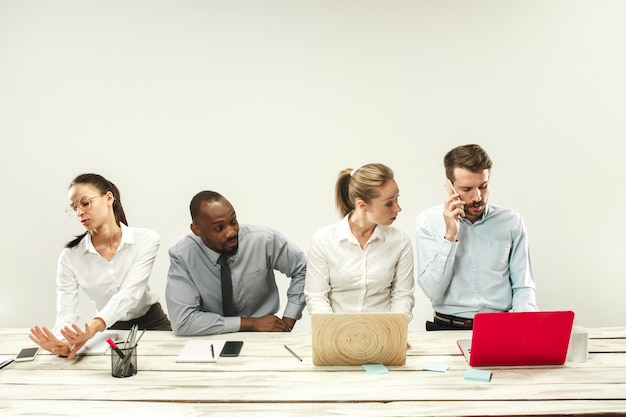 Homens novos e mulheres sentados no escritório e trabalhando em laptops. conceito de emoções