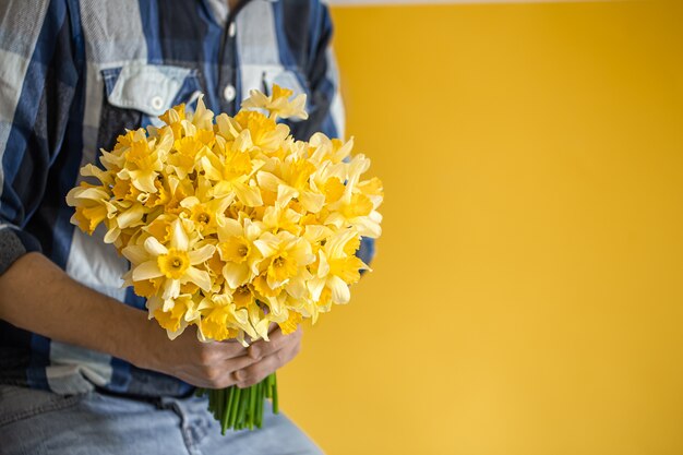 Homens segurando um grande buquê de narcisos.