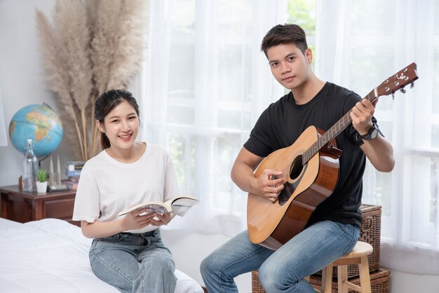 Homens sentados violão e mulheres segurando livros e cantando.