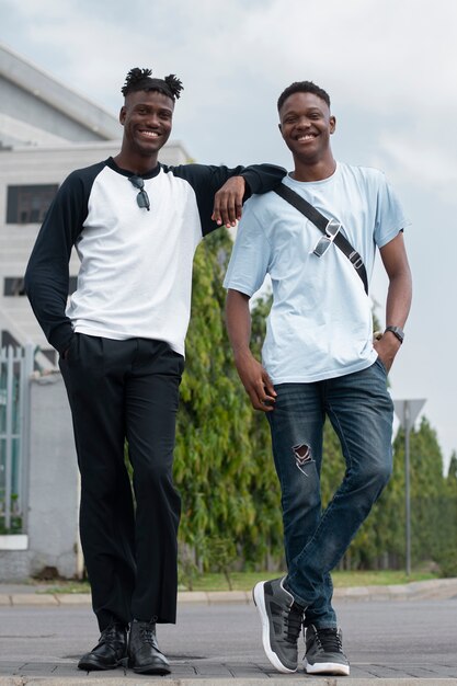 Homens sorridentes de tiro completo posando juntos