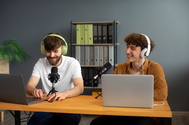 Homens sorridentes de tiro médio gravando podcast