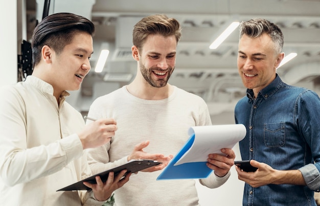 Foto grátis homens sorridentes discutindo sobre um projeto no trabalho