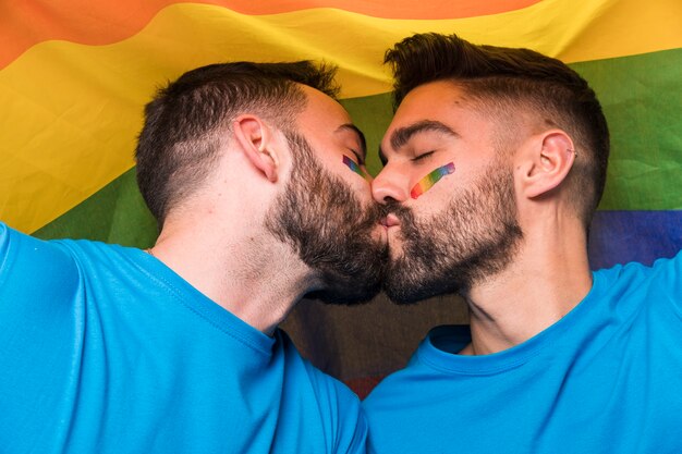 Homossexual, par, de, homens, beijando, ligado, bandeira multicoloured