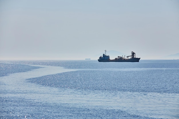 Horizonte nublado e neblina sobre o mar acena o navio de carga de fundo natural no horizonte