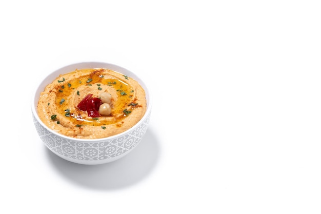 Hummus de pimenta vermelha assada em tigela branca isolada em fundo branco
