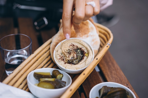 Hummus delicioso fresco, pão pita e pepinos em conserva