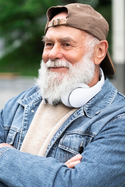 Idoso com fones de ouvido ao ar livre na cidade