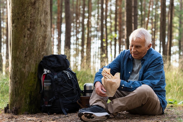 Idoso fazendo um lanche ao ar livre na natureza