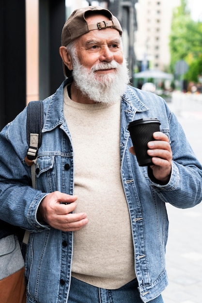 Idoso tomando uma xícara de café ao ar livre na cidade