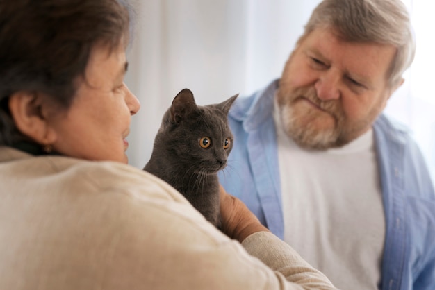 Foto grátis idosos de vista lateral com gato