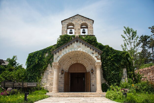 Igreja medieval com dois sinos tocando no topo