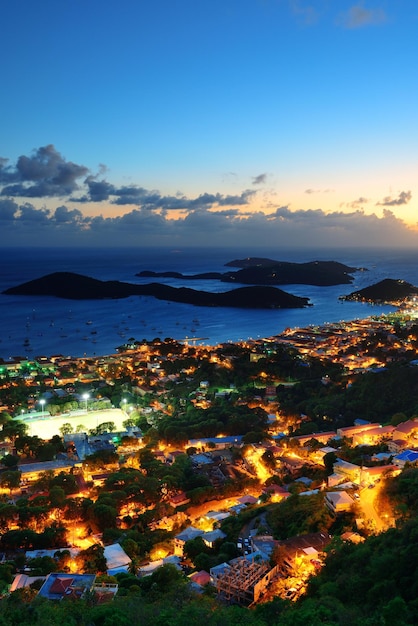 Ilhas virgens st thomas vista para a montanha por do sol com nuvens coloridas, edifícios e litoral de praia.