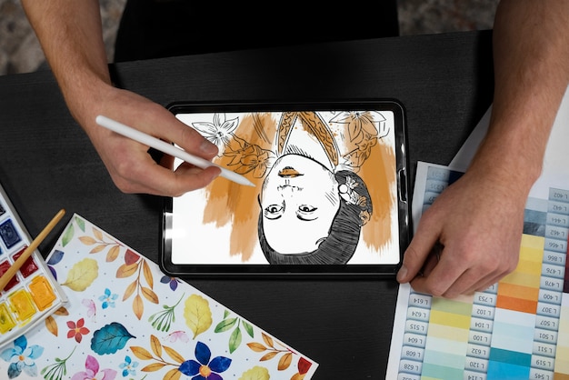 Foto grátis ilustrador de vista superior desenhando no ipad