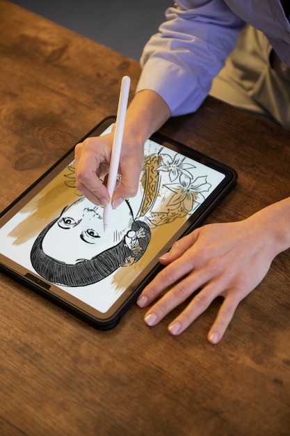 Ilustrador desenhando no ipad em alto ângulo