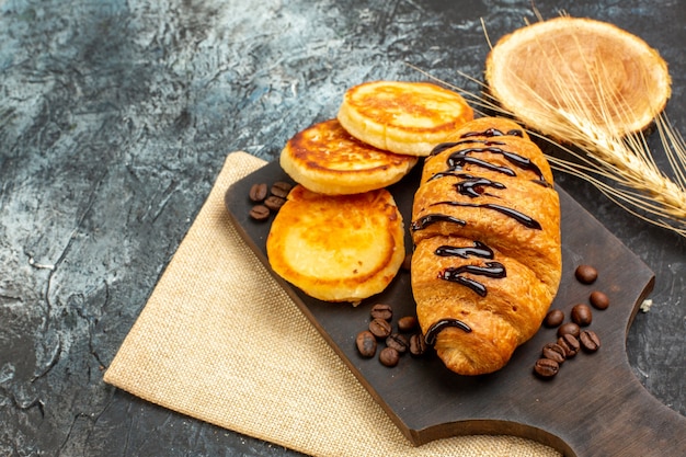 Imagem aproximada de deliciosas panquecas de croissant para o amado no lado esquerdo na superfície escura
