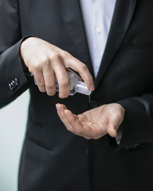 Imagem aproximada de uma pessoa usando um desinfetante para as mãos