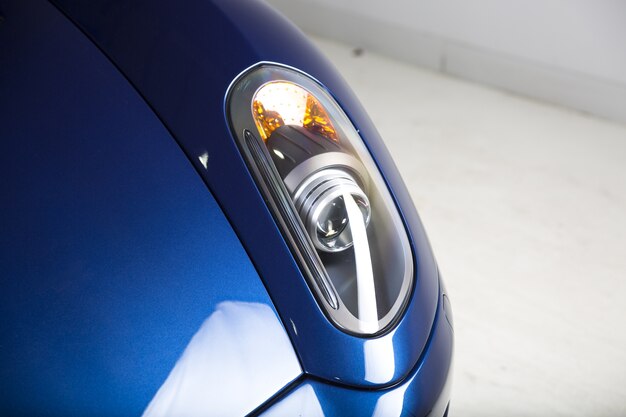 Imagem aproximada dos faróis de um carro azul moderno
