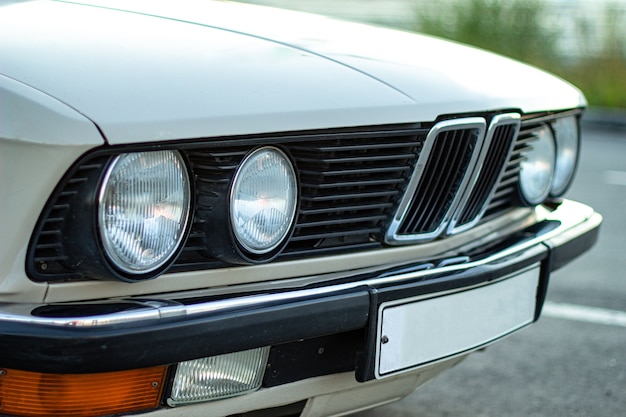 Imagem aproximada dos faróis redondos de um carro clássico vintage branco