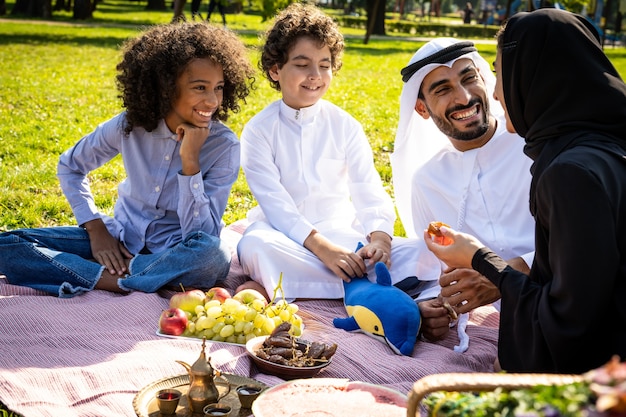 Imagem cinematográfica de uma família dos emirados passando um tempo no parque Foto Premium