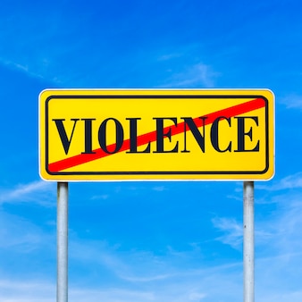Imagem conceitual de um sinal de trânsito amarelo brilhante mostrando a violência proibida com a palavra - violência - atravessada contra um céu azul.