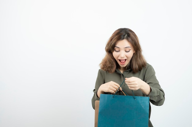 Imagem da linda garota de cabelos curtos com pé de sacos de compras. Foto de alta qualidade