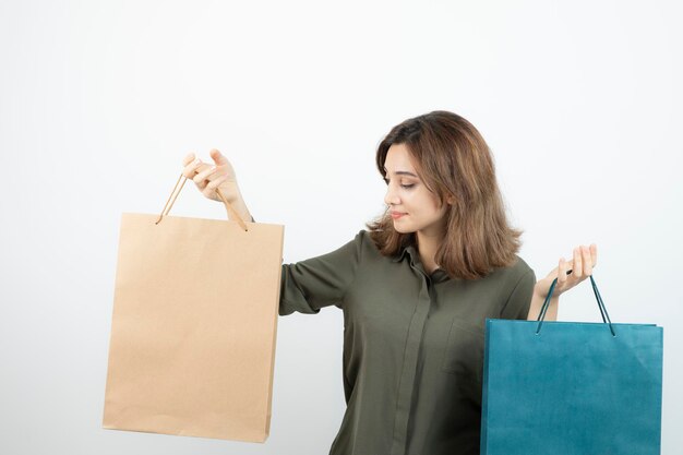 Imagem da linda garota de cabelos curtos segurando sacolas de compras. Foto de alta qualidade