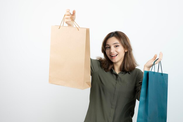 Imagem da linda garota de cabelos curtos segurando sacolas de compras. Foto de alta qualidade