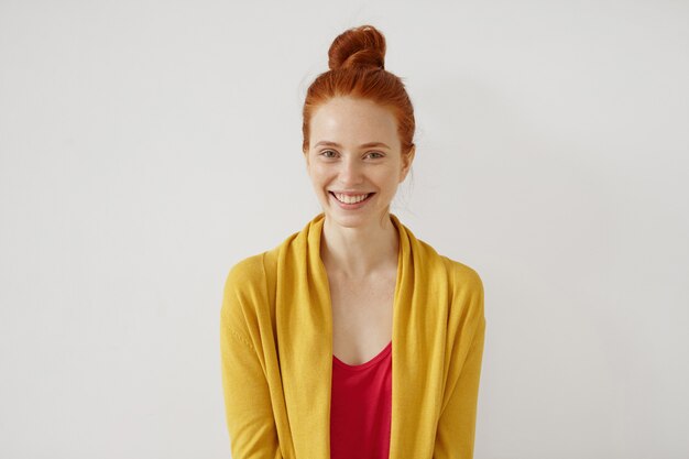 Imagem de atraente ruiva jovem atraente com sardas vestida casualmente, sorrindo amplamente, feliz com boas notícias.