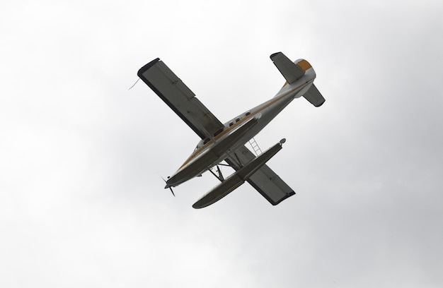 Imagem de baixo ângulo de um hidroavião voando sobre o céu claro