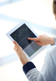 Imagem de close-up de um funcionário de escritório usando um touchpad para analisar dados estatísticos