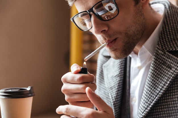 Imagem de close-up do empresário em óculos, sentado junto a mesa