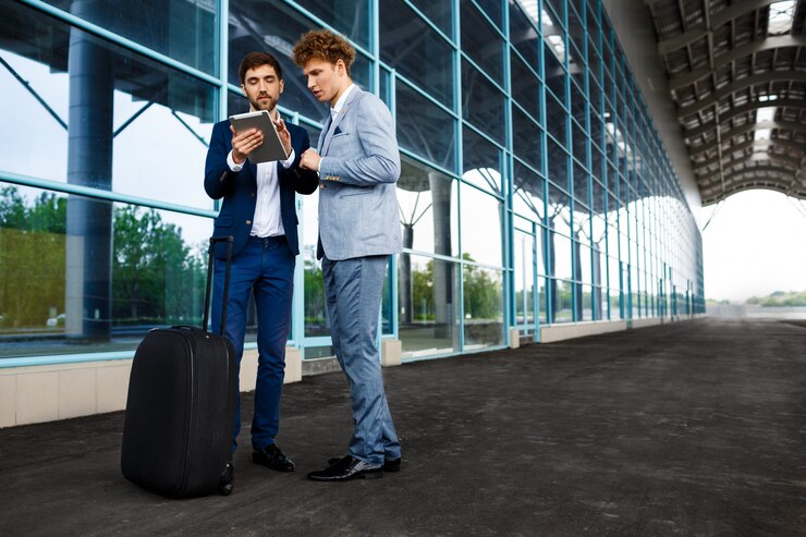 Foto grátis imagem de dois jovens empresários falando na estação e segurando o tablet