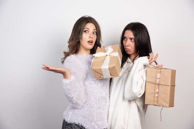 Imagem de dois melhores amigos juntos segurando caixas de presente.