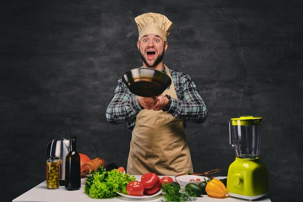 Imagem de estúdio do cozinheiro chef masculino preparando refeições em uma panela.