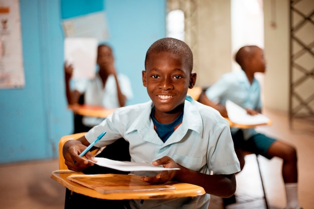 Imagem de foco raso de uma criança africana aprendendo na escola