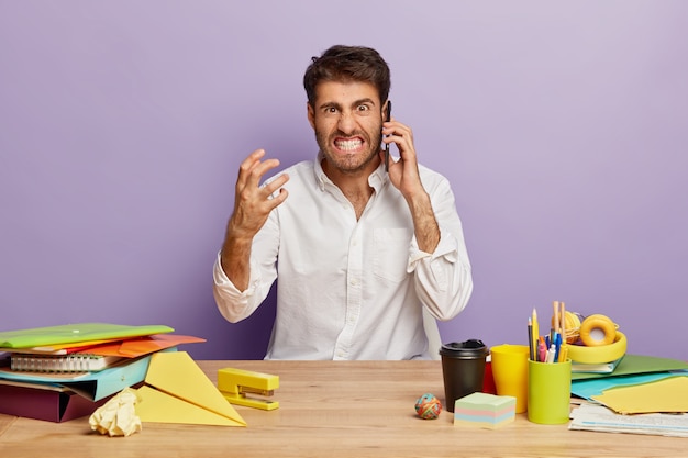 Foto grátis imagem de funcionário irritado sentado à mesa do escritório