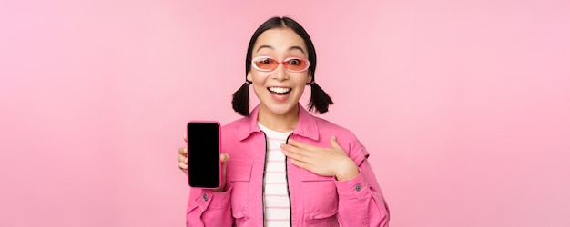 Imagem de garota surpreendida mostrando a tela do aplicativo do telefone móvel interface do aplicativo de exibição do smartphone sta