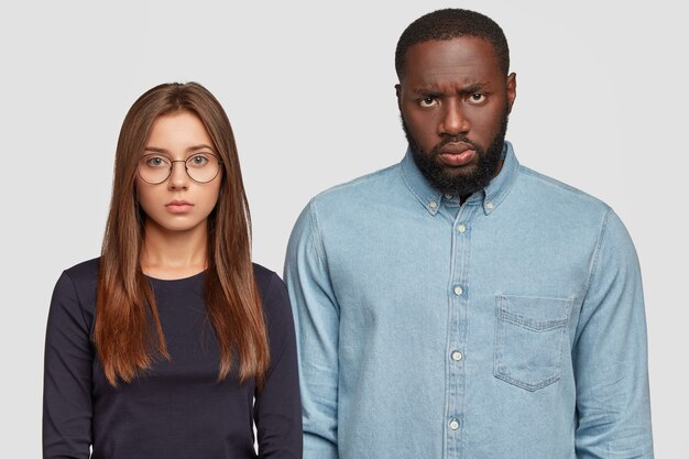 Foto grátis imagem de homem e mulher inter-raciais sérios e sombrios olham diretamente