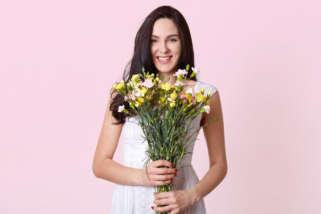 Imagem de menina segurando buquê de flores nas mãos