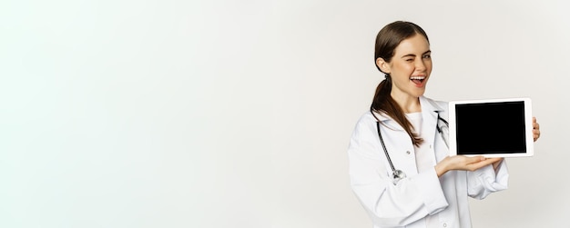 Foto grátis imagem de mulher médica profissional de saúde mostrando a tela do tablet digital do site médico on-line
